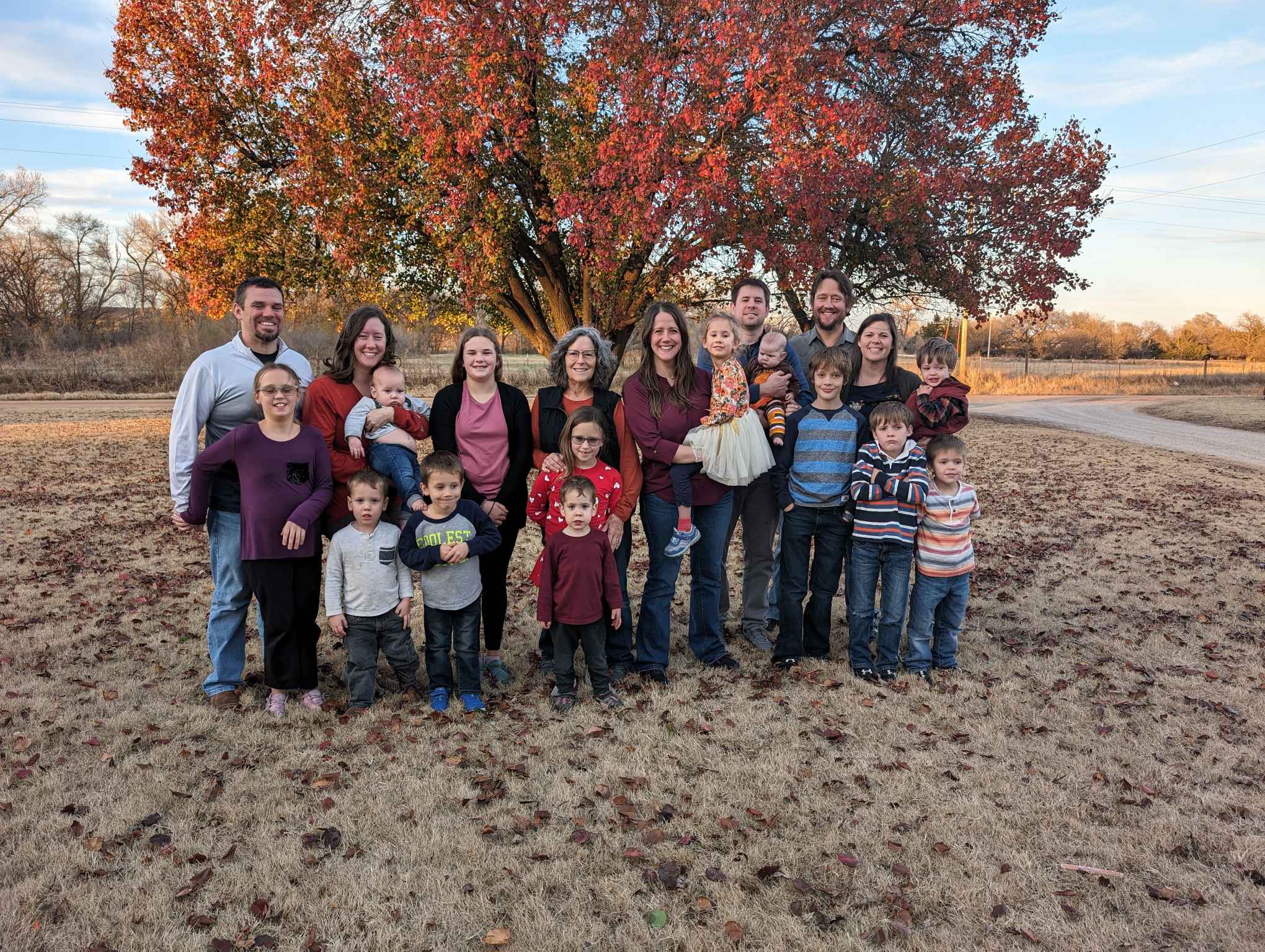 The Traffas family gathered under a maple tree in autumn